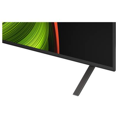Un angolo televisivo con un moderno schermo piatto, poggiante su un supporto metallico elegante, con vibranti pattern astratti in verde e rosso sullo schermo.