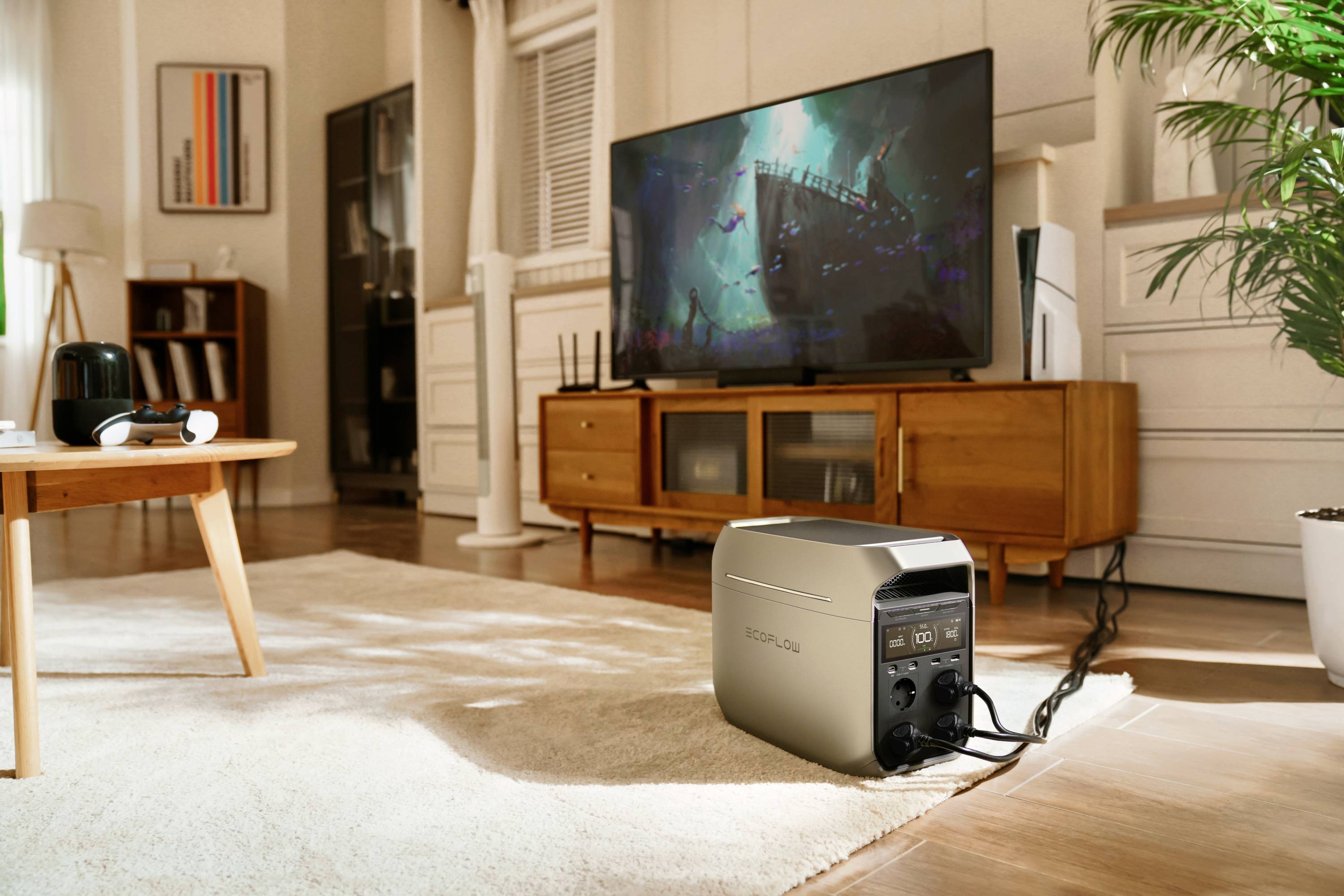 Un generatore di corrente portatile è posizionato in un soggiorno. È collegato a un sistema di intrattenimento. Sullo sfondo, un film sta riproducendosi sulla televisione.