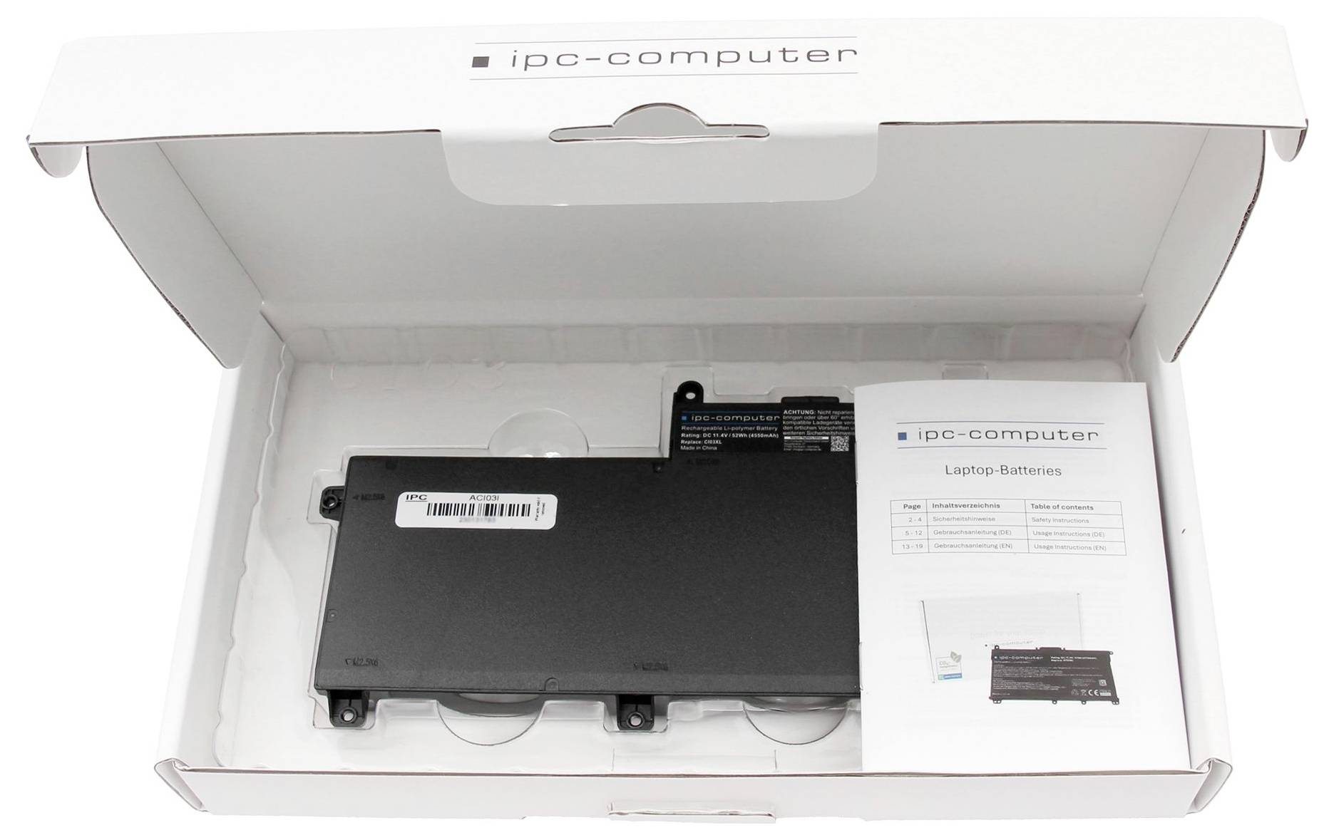 Una batteria per laptop è posizionata in una confezione aperta accanto a un manuale di istruzioni e a un piccolo adesivo informativo.