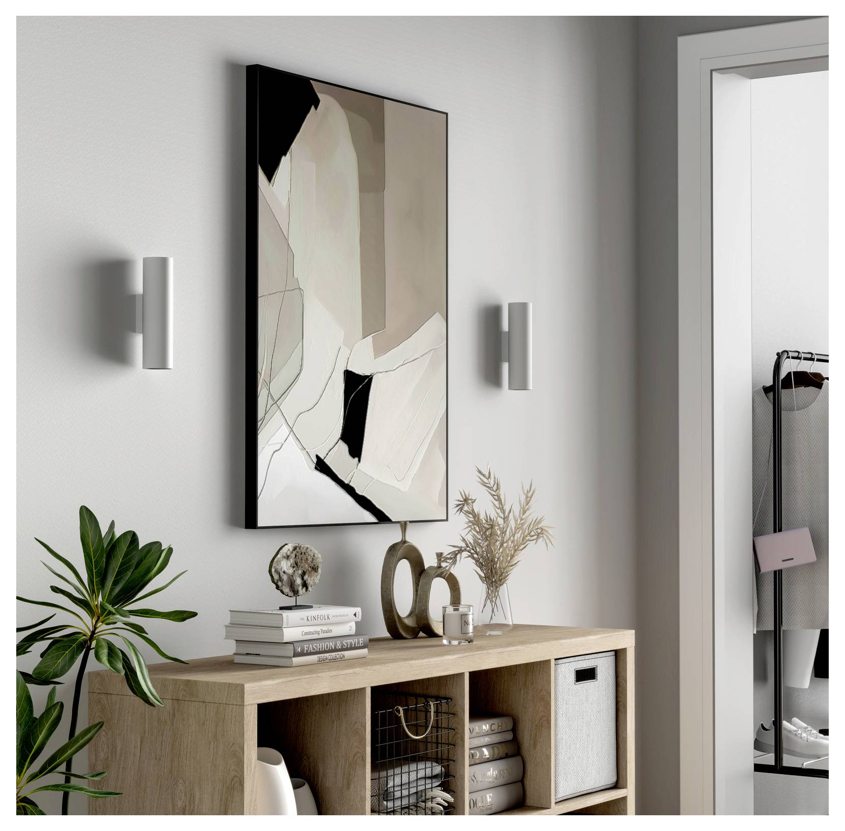 Ingresso moderno con un'opera d'arte astratta sopra una console in legno, affiancata da appliques a parete e decorata con libri, una pianta, un vaso e contenitori portaoggetti.