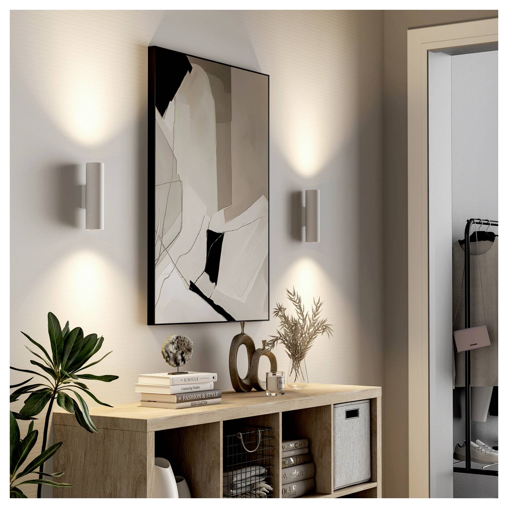 Ingresso moderno con una console in legno, un'opera d'arte astratta a parete, appliques, piante, oggetti decorativi e un'apertura senza porta che conduce a un guardaroba.