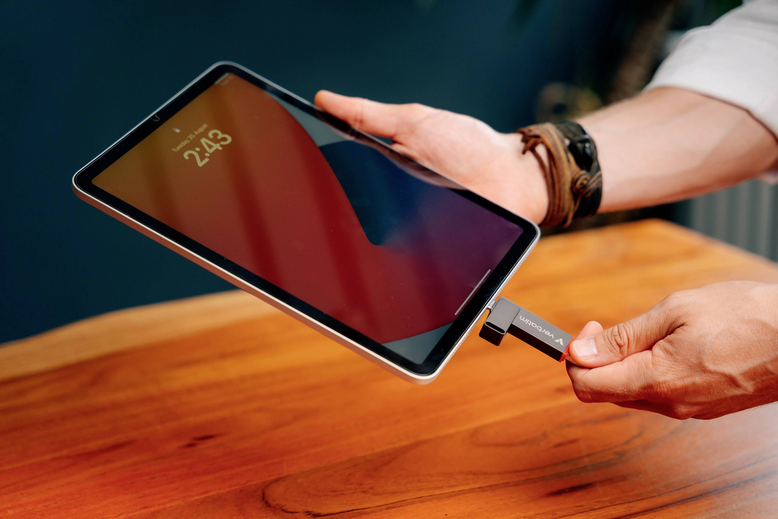 Una persona tiene un tablet nella mano sinistra e inserisce una chiavetta USB-C nel tablet con la mano destra.