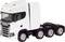 Camion bianco con quattro pneumatici posteriori, griglia del radiatore distintiva e cabina di guida aerodinamica, fermo su strada asfaltata.