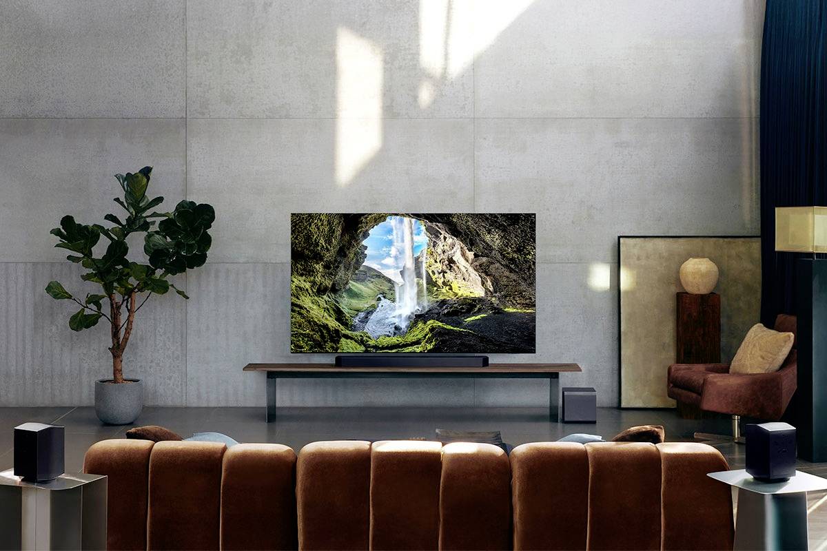 Un soggiorno moderno con un grande televisore su un tavolo basso. Lo schermo mostra una grotta con una cascata.
