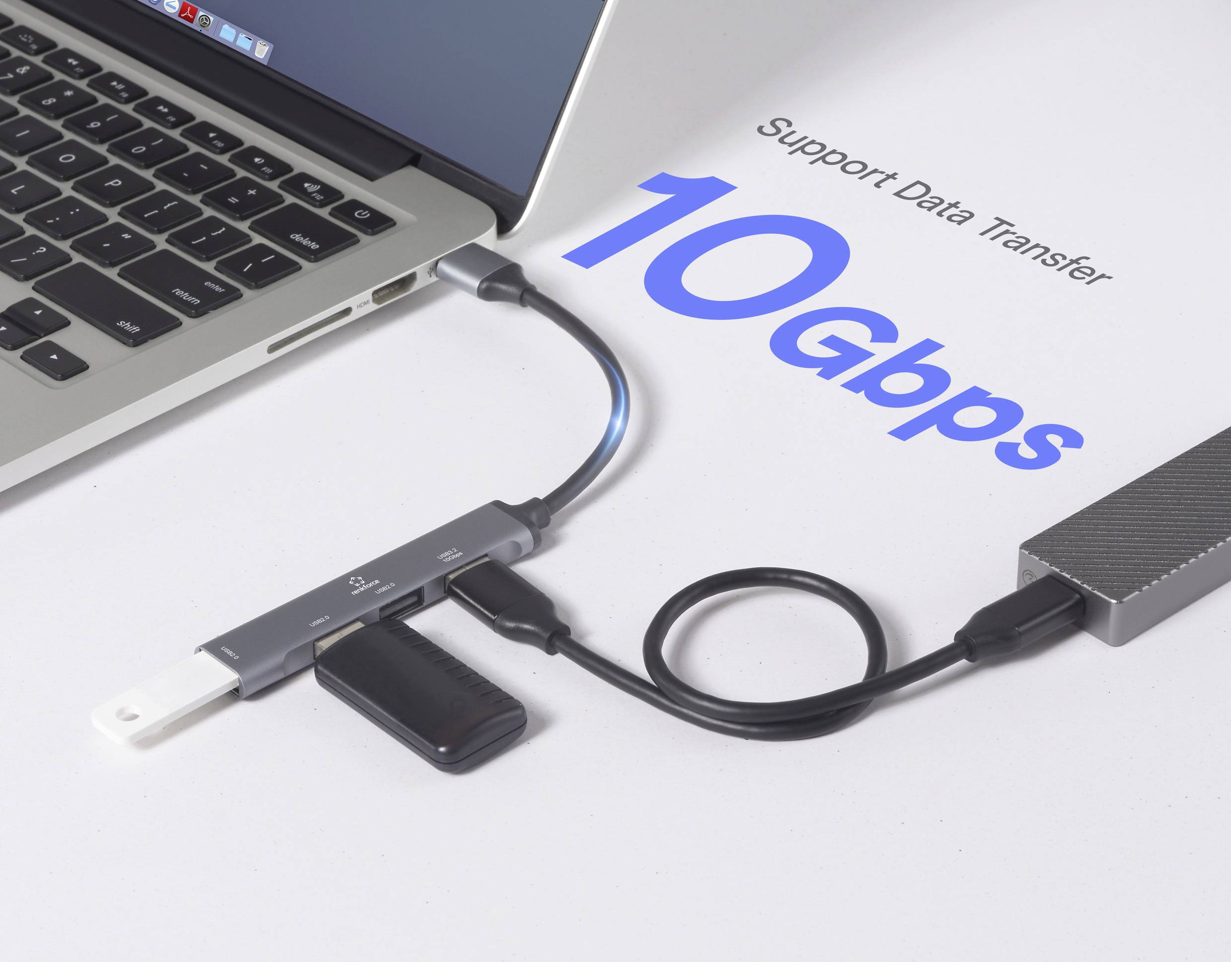 Un laptop collegato a un hub USB con vari dispositivi collegati, che mostra 'Supporto Trasferimento Dati 10 Gbps' che indica un trasferimento ad alta velocità.
