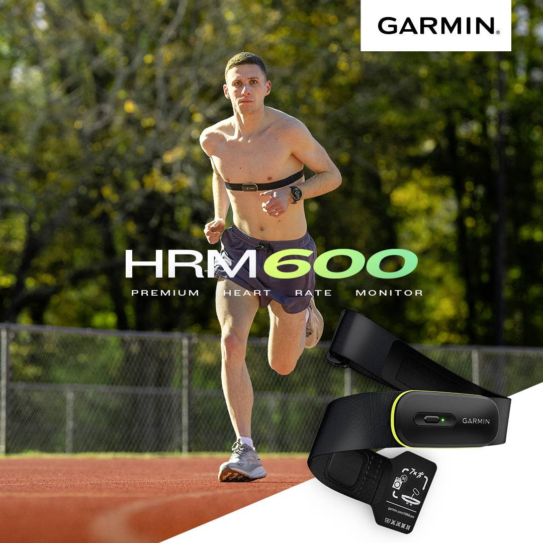 Un corridore si allena su una pista rossa indossando un cardiofrequenzimetro sul petto. In primo piano un dispositivo Garmin HRM 600.