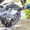 Una persona utilizza un idropulitrice con sapone per pulire un pneumatico di motocicletta. La schiuma ricopre la ruota, indicando una pulizia accurata.