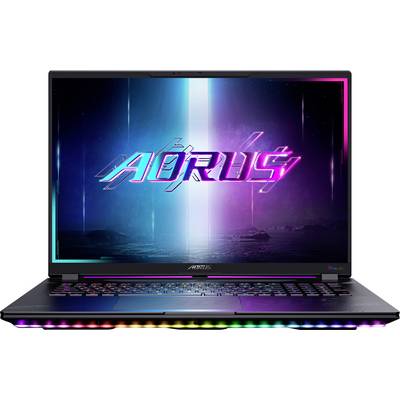 Un laptop che mostra un logo AORUS colorato e futuristico sullo schermo, con illuminazione RGB visibile sulla tastiera e sul bordo anteriore.