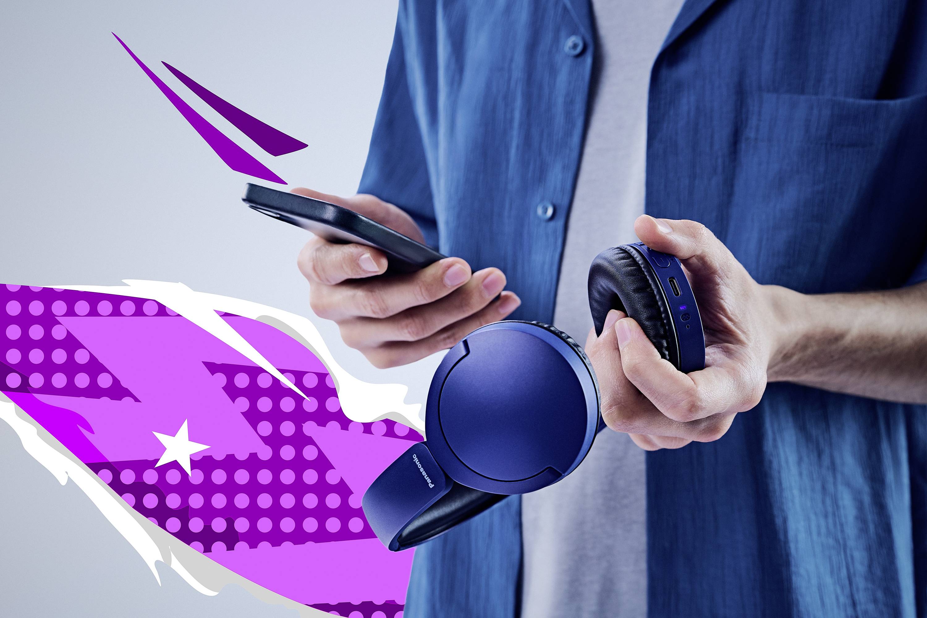 Una persona tiene uno smartphone e auricolari wireless blu su uno sfondo astratto viola con forme stilizzate.