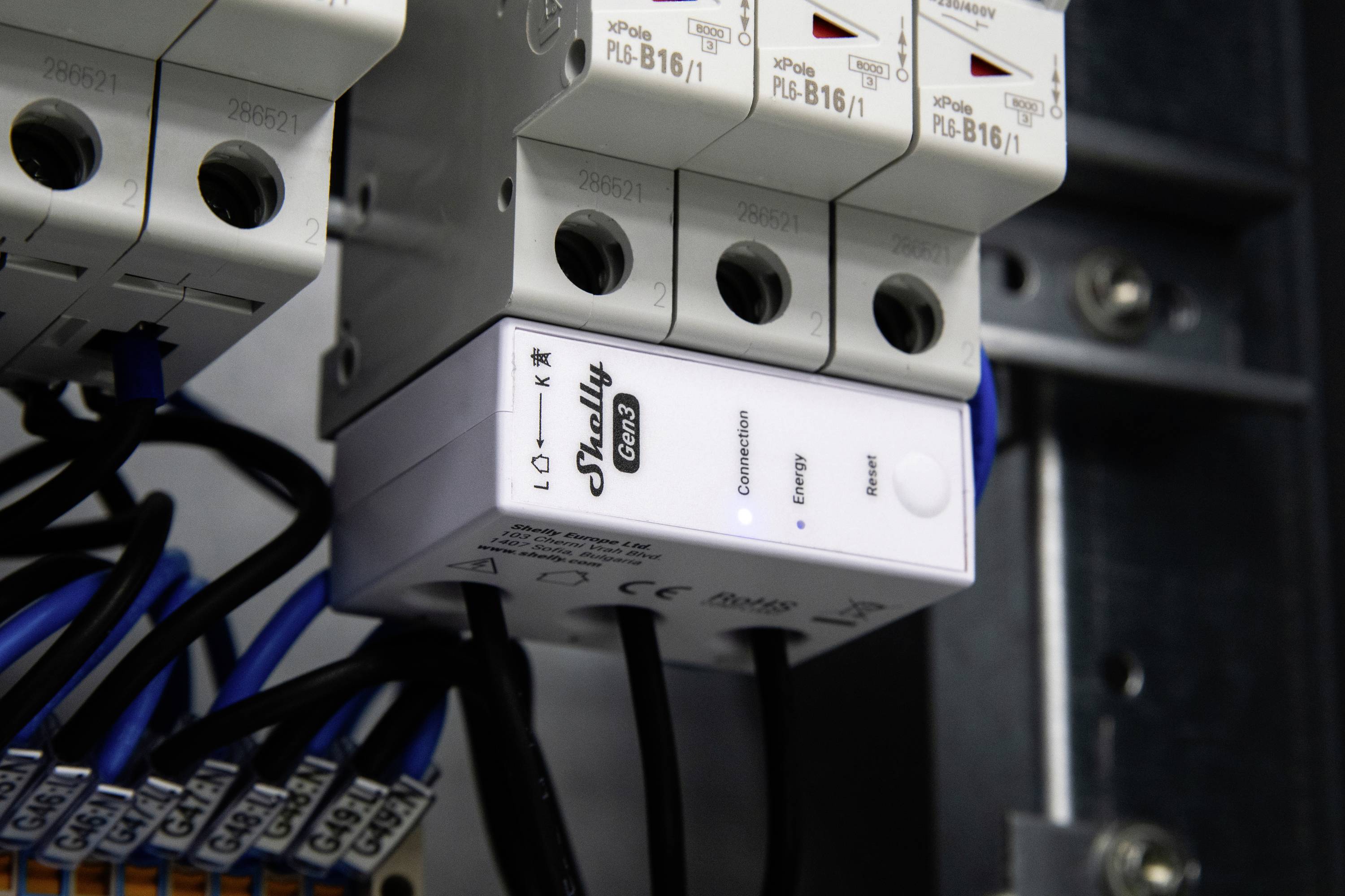 Quadro elettrico con interruttori automatici e un modulo etichettato 'Shelly Pro 3EM' per la gestione energetica, con cablaggio visibile.