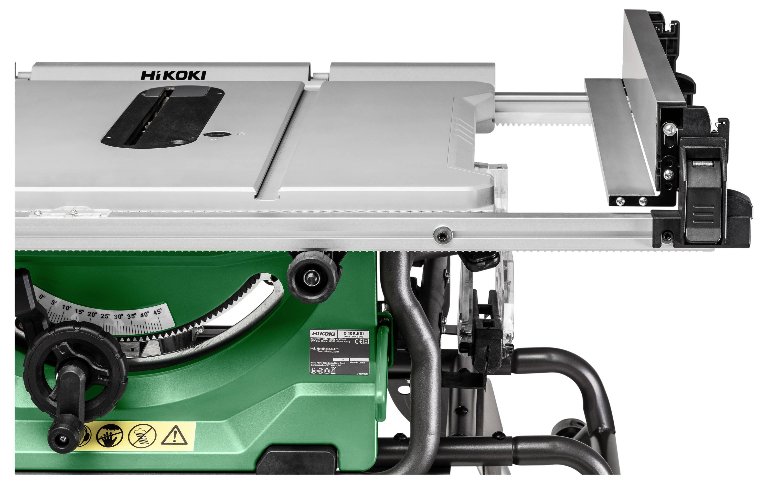 Un banco sega con base verde, piano di lavoro argentato e etichette di avvertimento di sicurezza visibili, utilizzato per tagliare materiali in falegnameria o edilizia.