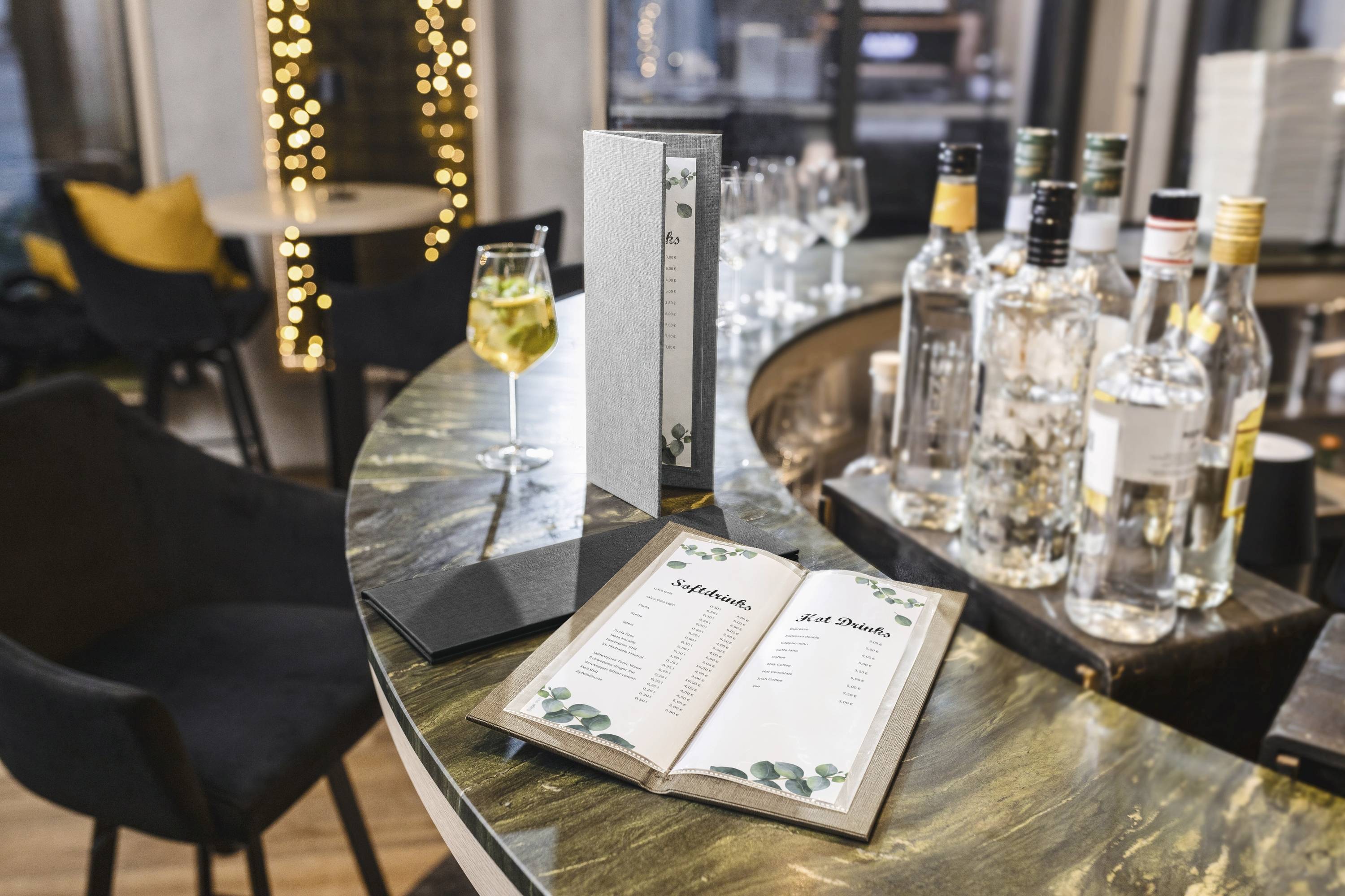 Un ambiente bar elegante con un menu dei cocktail aperto su un bancone di marmo, circondato da bottiglie di alcolici, un cocktail e sedute raffinate.