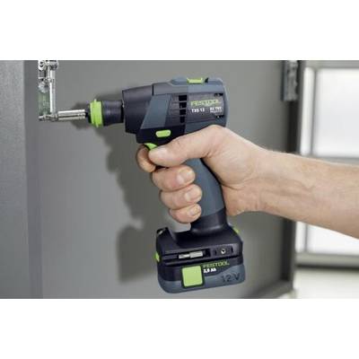 Una persona che utilizza un trapano elettrico cordless per serrare una vite su una cerniera metallica fissata a un'anta di un mobile. Il trapano è impugnato saldamente con la mano.