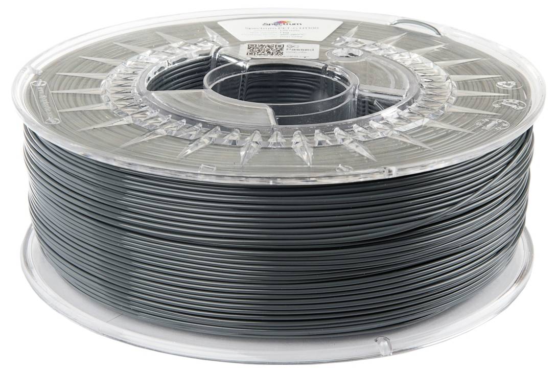 Un rocchetto di filamento per stampante 3D grigio scuro, avvolto ordinatamente, posizionato su un supporto trasparente in plastica.