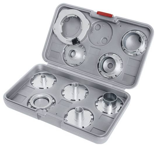 Un contenitore grigio aperto contenente sei accessori per tagliare la pasta, ciascuno con forme diverse, da utilizzare con una macchina per pasta.
