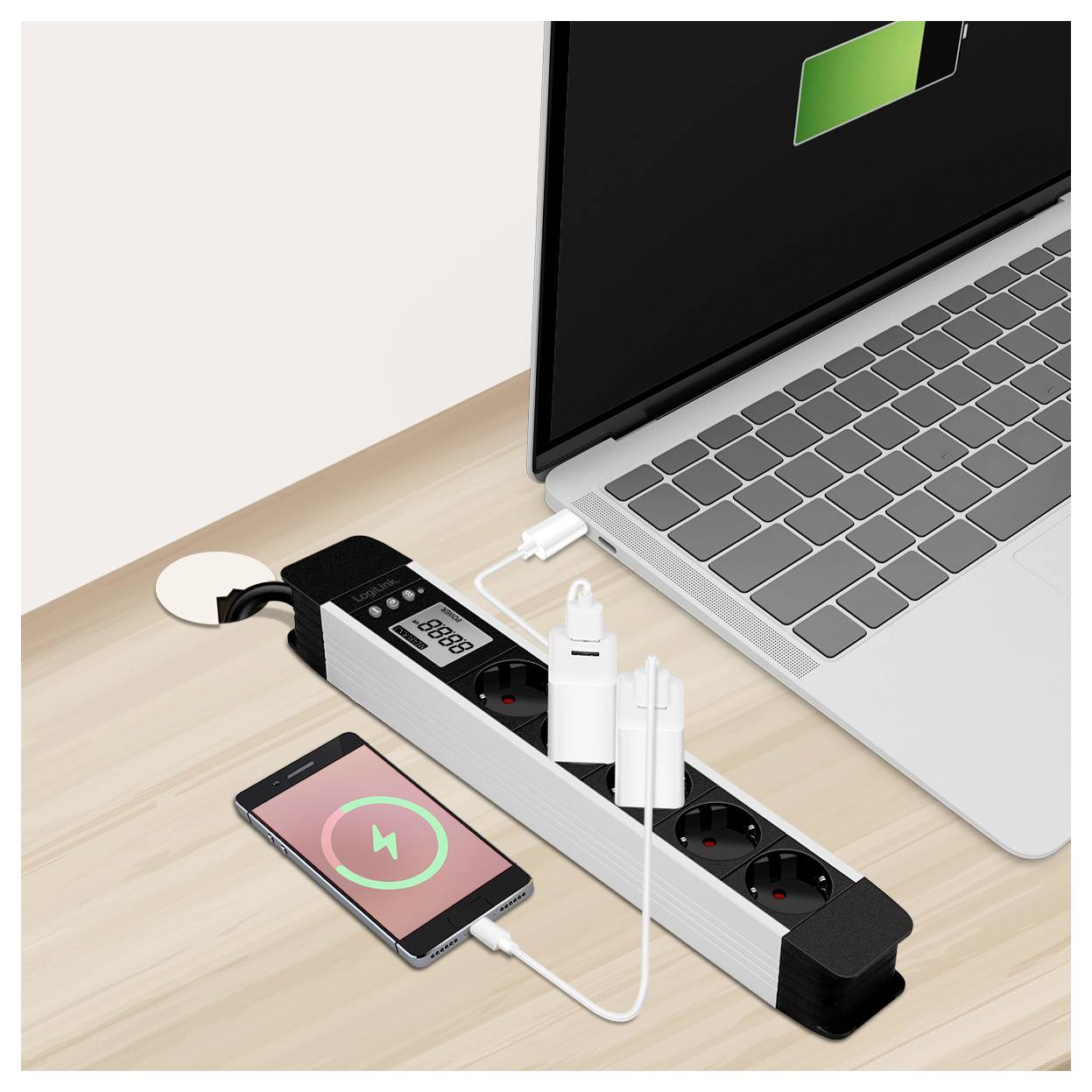 Una ciabatta su un tavolo sta caricando uno smartphone e un laptop. Lo schermo del laptop mostra un'icona di carica della batteria, e lo smartphone mostra un simbolo di ricarica.