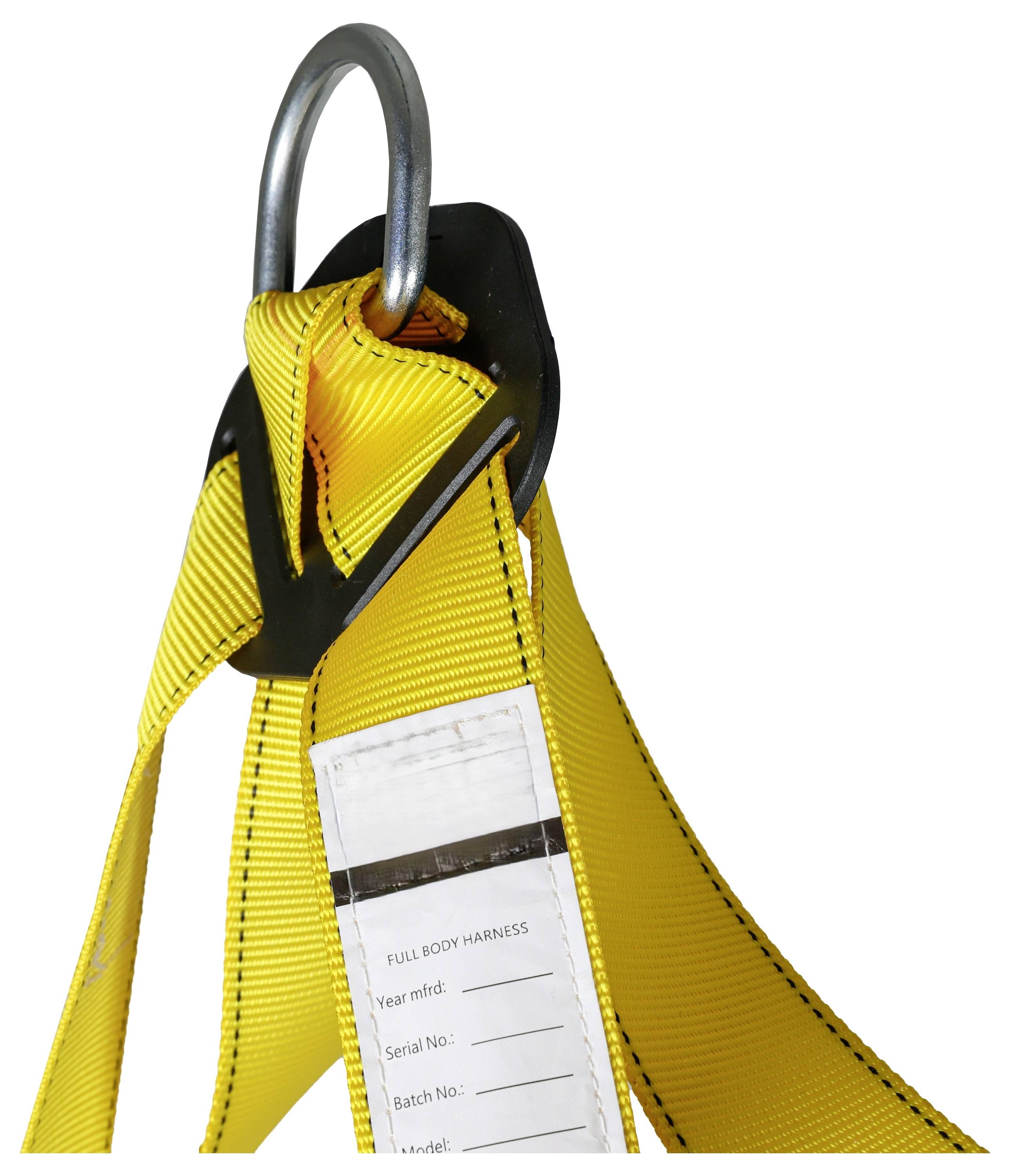 Un primo piano di un'imbracatura di sicurezza gialla con un anello a D in metallo. Un'etichetta con i dettagli di fabbricazione è applicata all'imbracatura.
