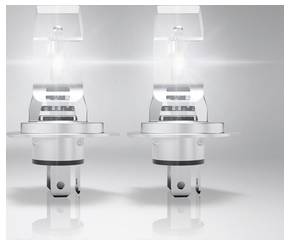 Due lampadine per fari di automobili argentate sono illuminate su uno sfondo grigio, mostrando design e luminosità.