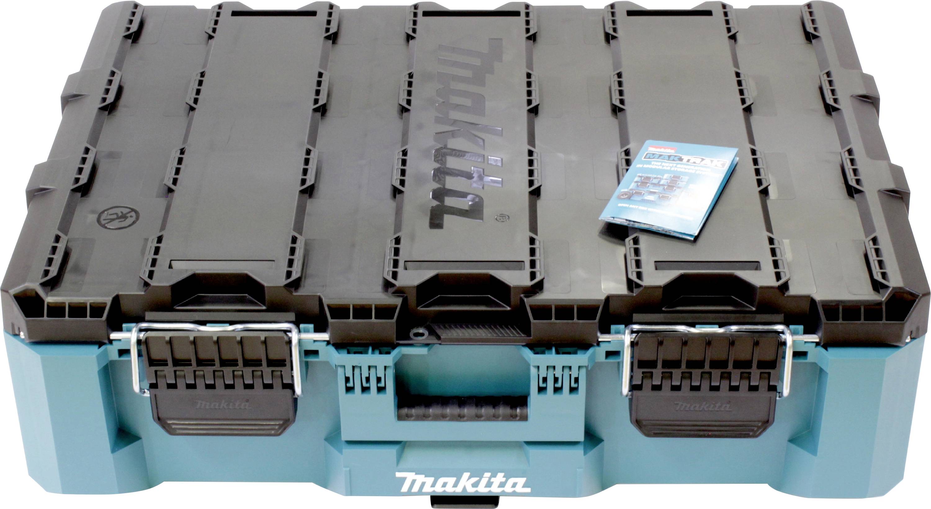 Un robusto e grande contenitore per utensili Makita nei colori blu e nero è chiuso, con un piccolo manuale di istruzioni poggiato sopra.