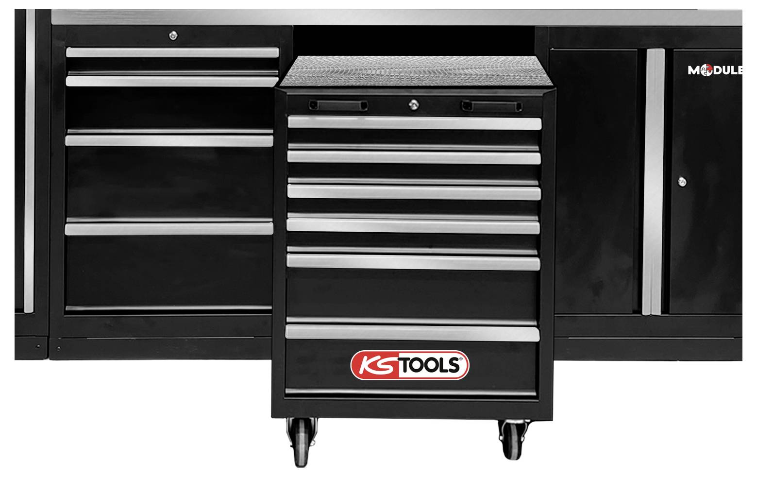 Un armadietto degli attrezzi nero con più cassetti, etichettato 'KS TOOLS', posizionato tra armadi più grandi, che suggerisce un ambiente di officina.