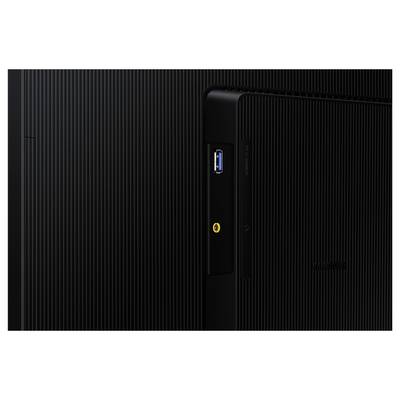 Un primo piano di un dispositivo elettronico nero che mostra una porta USB e un connettore giallo sul lato, su una superficie testurizzata e scanalata.
