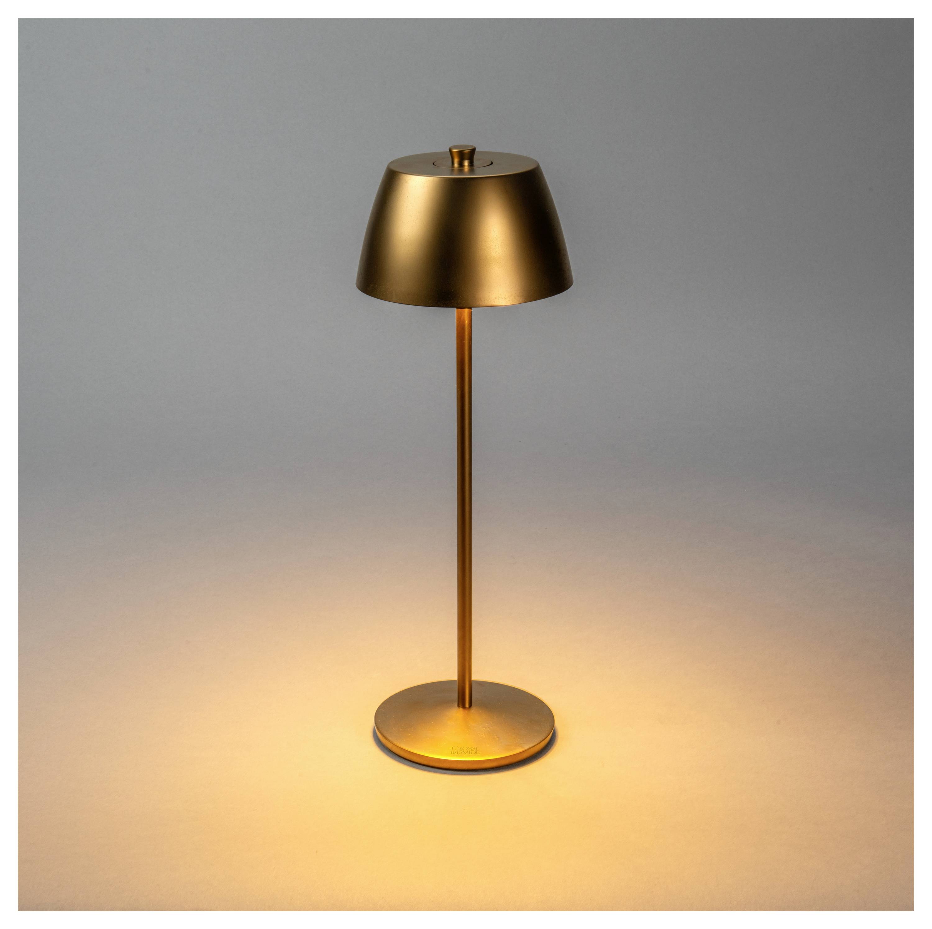 Una lampada elegante e moderna in rame su una superficie piana, che emana un bagliore caldo e soffice, creando un'atmosfera accogliente in un contesto minimista.