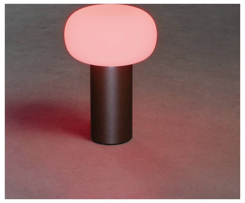 Un lampione a forma di fungo rosso brillante su una superficie grigia.