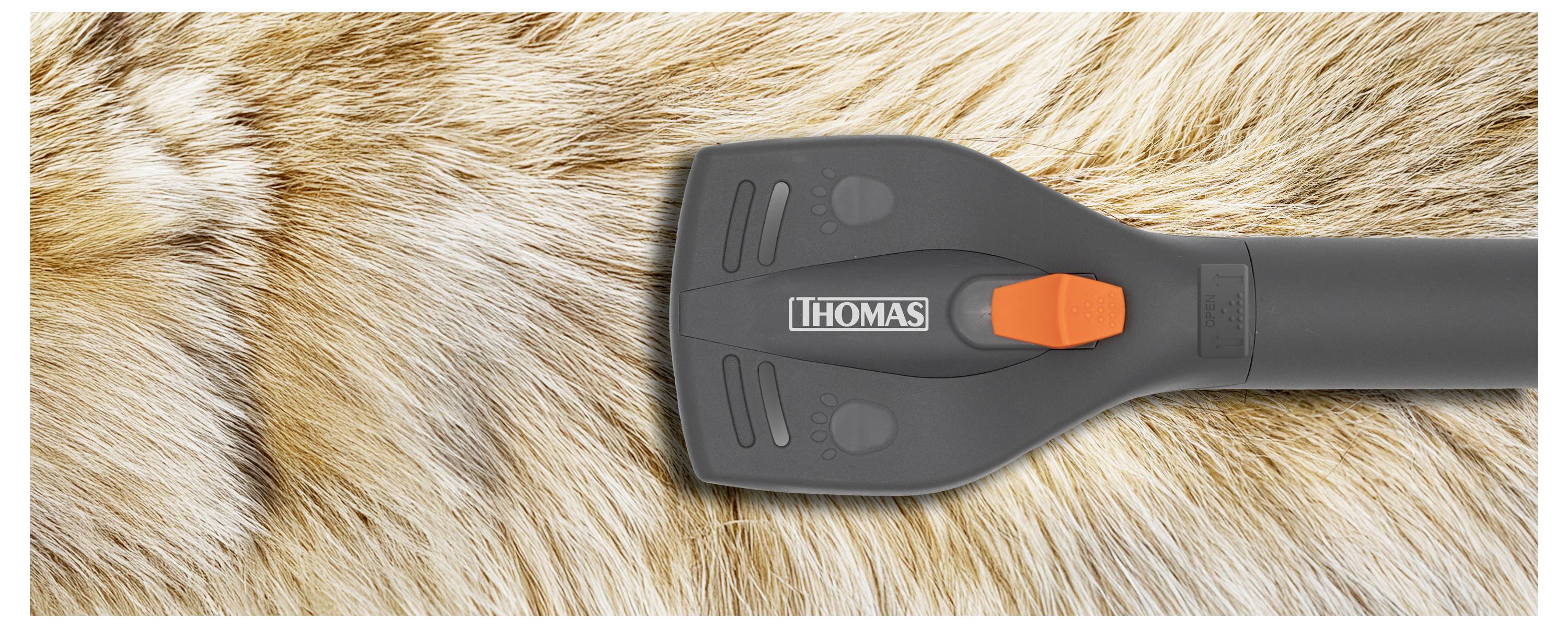 Una testina di aspirapolvere con il marchio 'Thomas' è mostrata su una superficie pelosa, illustrando il suo scopo di pulizia dei peli degli animali domestici o di tessuti simili.