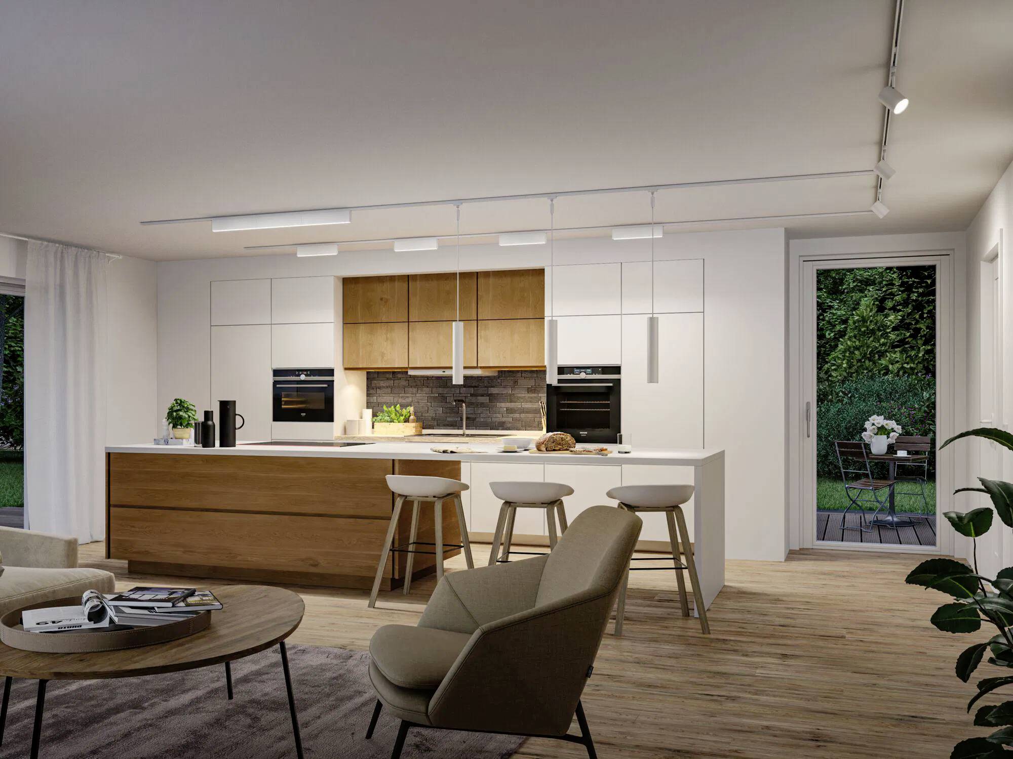 Cucina moderna con isola in legno, sgabelli da bar e elettrodomestici da incasso. La disposizione aperta conduce a un ponte con vista giardino attraverso una porta a vetri.