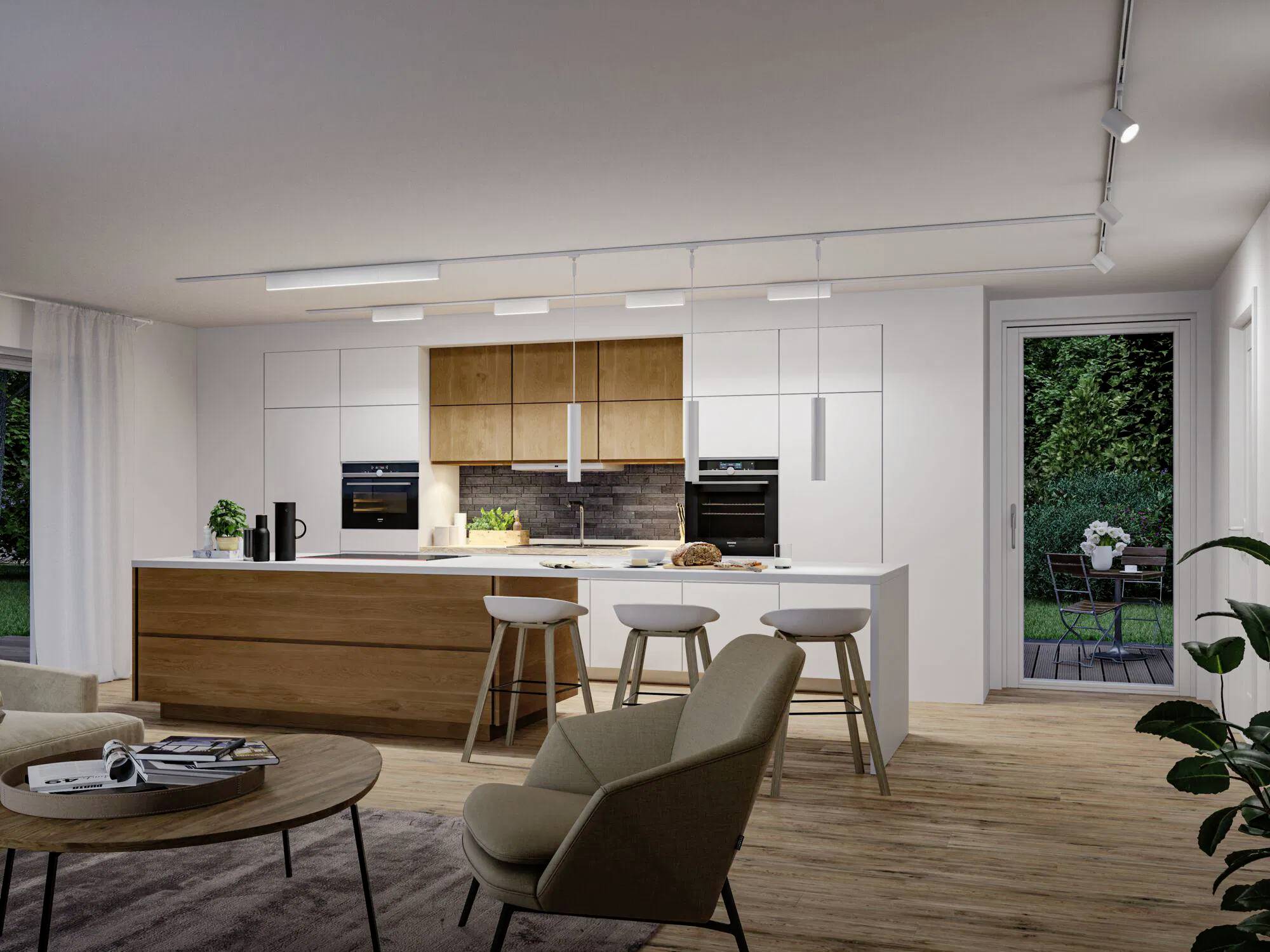 Cucina moderna con finiture in legno e bianco, che presenta un'isola con sgabelli, forni incassati e grandi finestre che si affacciano su un giardino.