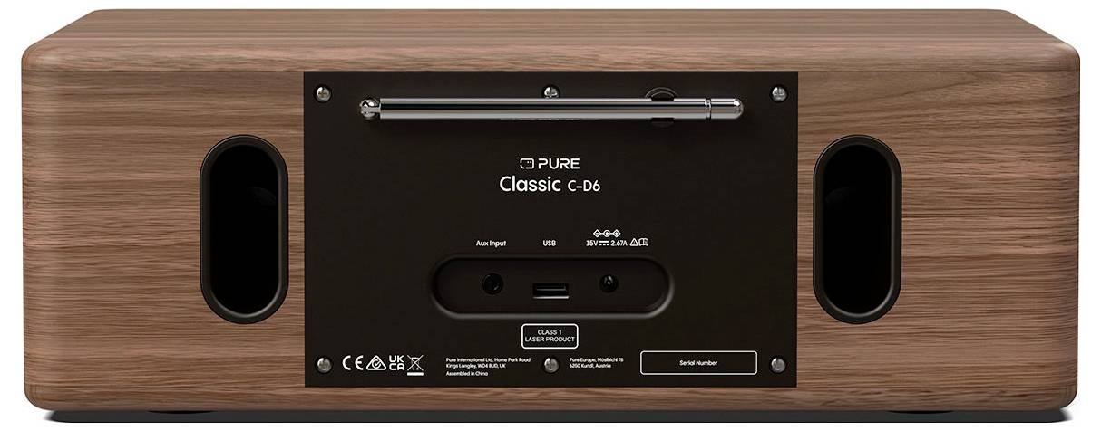 L'immagine mostra il pannello posteriore di un dispositivo audio 'Classic C-06' con porte di connessione, tra cui ingresso aux e opzioni di alimentazione, su una superficie in legno.