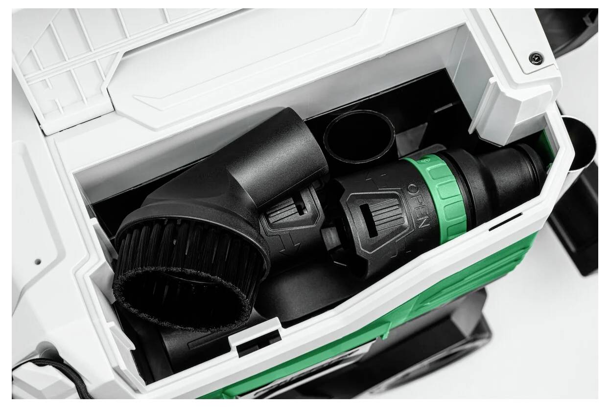 Un vano portaccessori per aspirapolvere, aperto per mostrare gli accessori in nero e verde ordinatamente sistemati al suo interno.