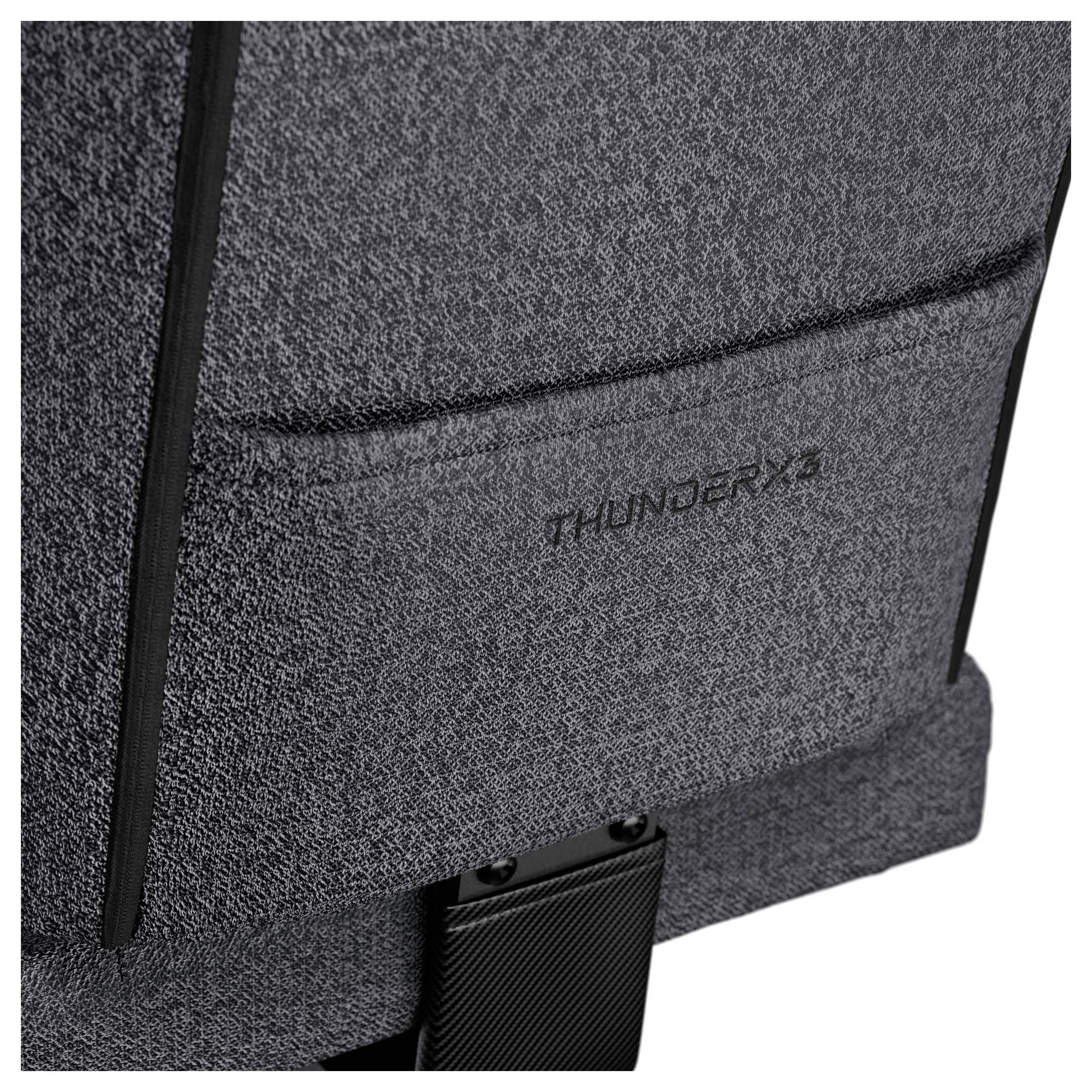 Primo piano di un tessuto grigio con la parola 'THUNDERX3' ricamata in nero, probabilmente parte di un mobile o di un accessorio.