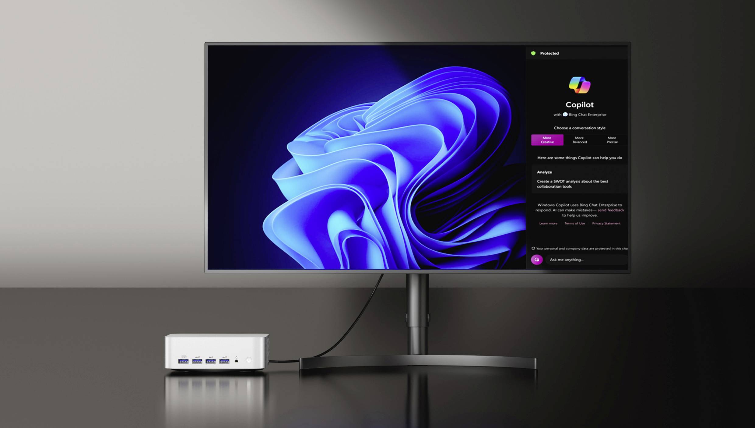 Un monitor computer elegante che mostra un design astratto blu vibrante, collegato a un'unità desktop compatta bianca, entrambi posizionati su una superficie lucida.