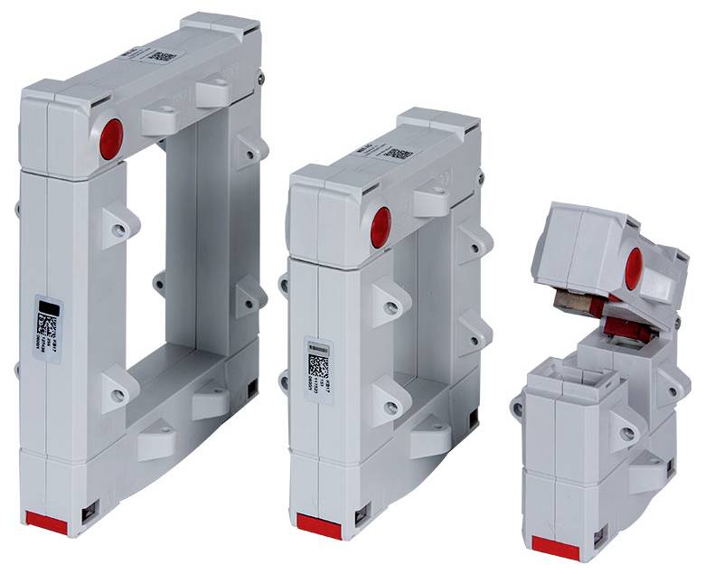 Tre trasformatori di corrente elettrica grigi di dimensioni diverse sono raffigurati, ciascuno con un fermo rosso e più staffe di montaggio.