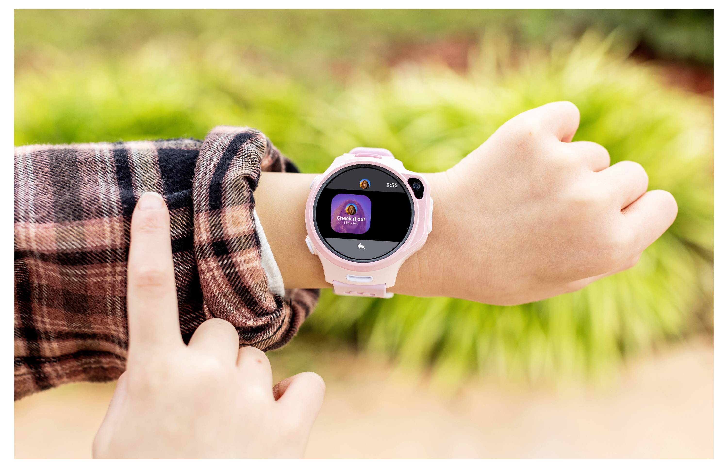 Una persona che indossa uno smartwatch al polso, con uno sfondo esterno sfocato. Lo schermo mostra un'icona e del testo.