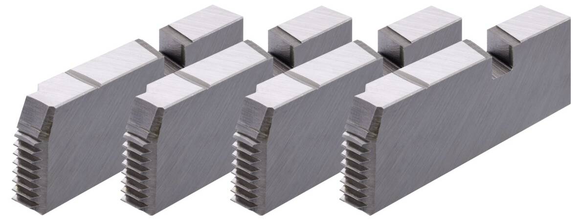 Quattro parti metalliche argentate con bordi zigrinati e forme rettangolari, allineate in fila, probabilmente componenti meccanici.