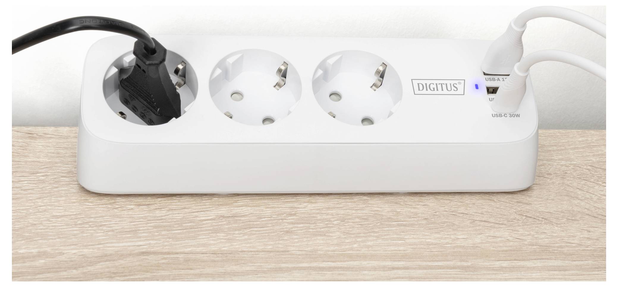Una ciabatta bianca con tre prese europee, due porte USB e il marchio 'DIGITUS'. Una presa e entrambe le porte USB sono in uso.