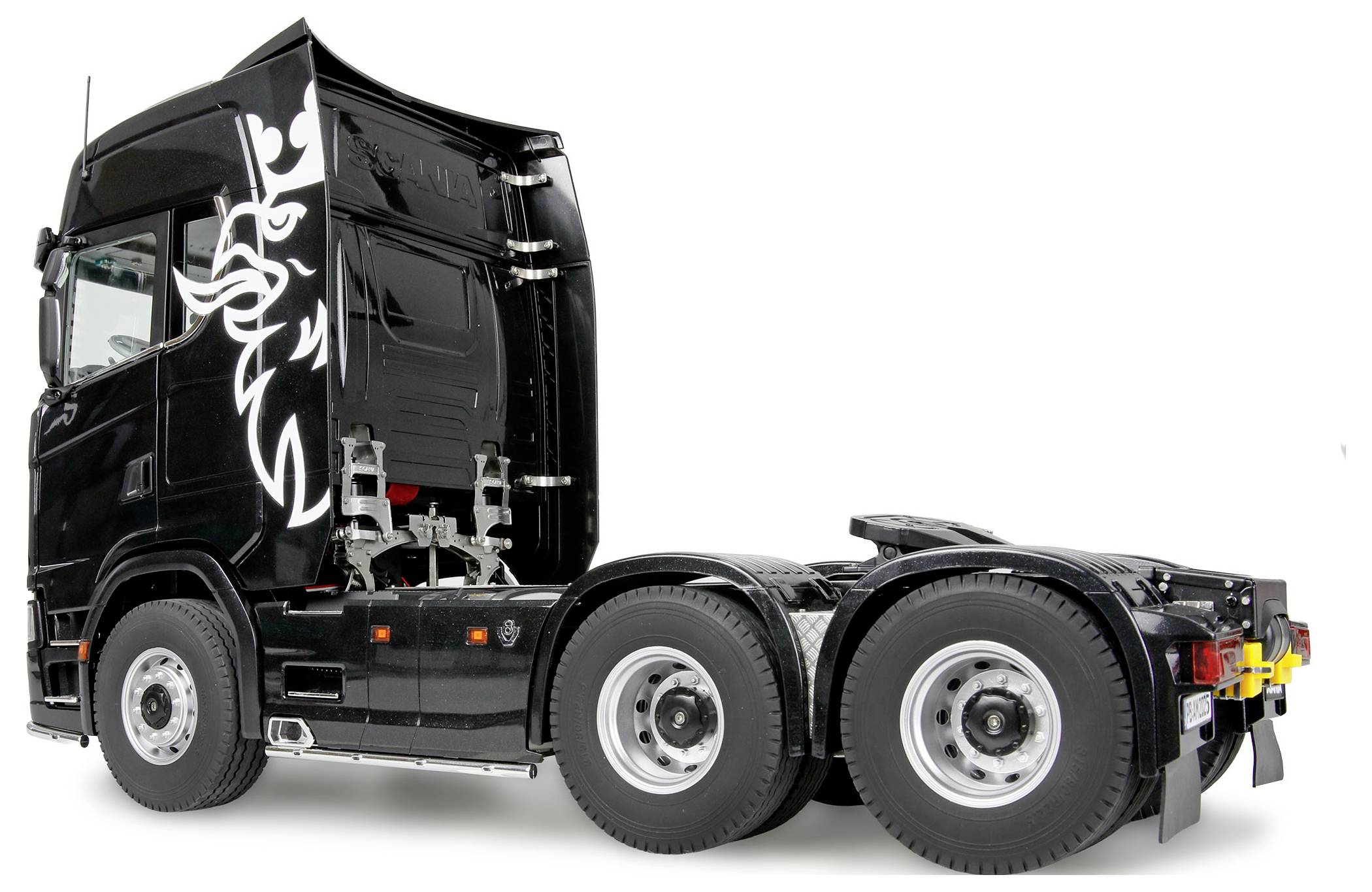 Cabina di un camion semi-rimorchio nero con un design stilizzato di un animale sul lato, senza rimorchio attaccato, vista dall'angolazione posteriore tre quarti.