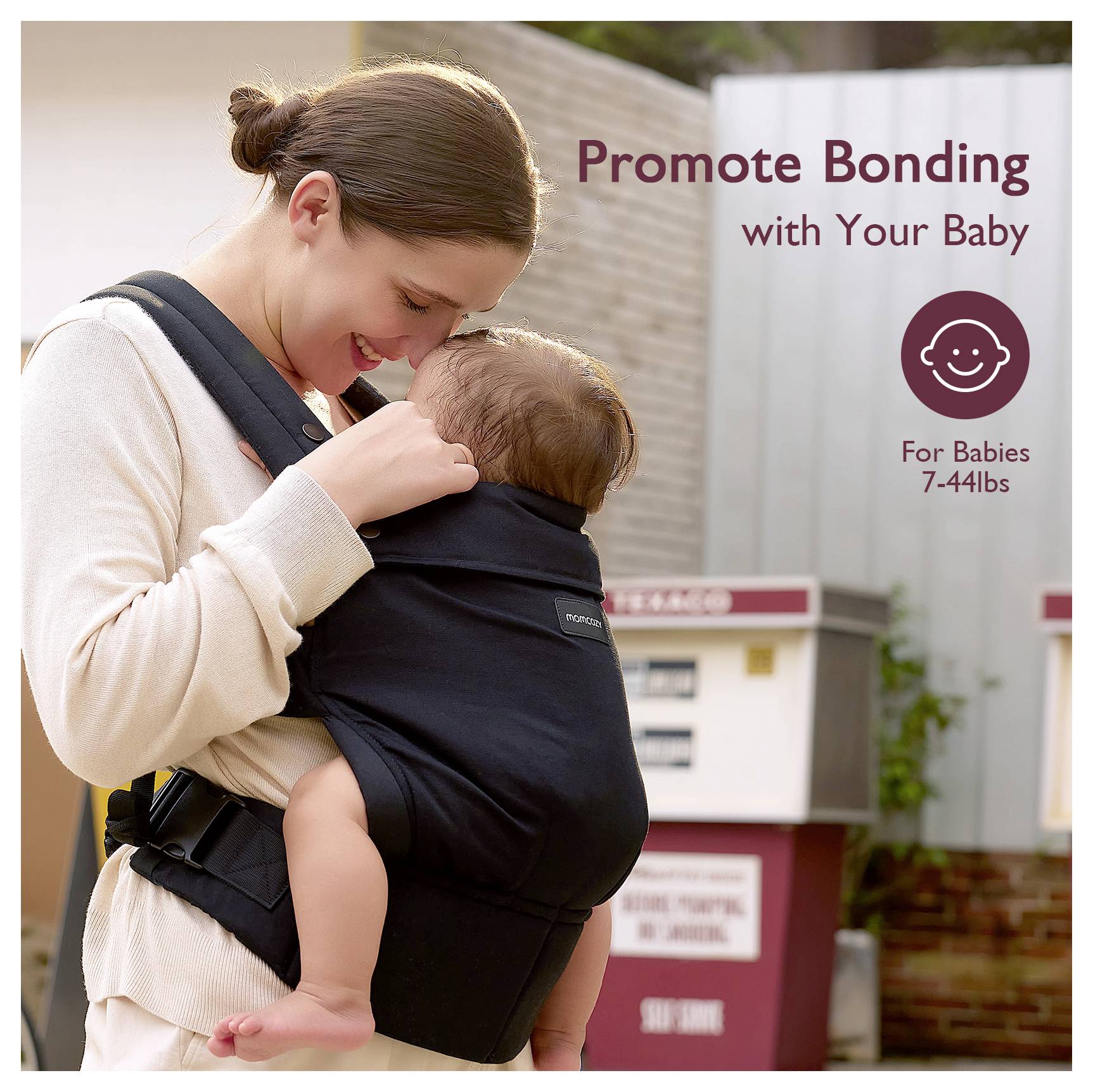 Una donna sorride al suo bambino, sistemato in un marsupio nero. Il testo recita 'Favorisci il legame con il tuo bambino'. Adatto a bambini da 3 a 20 kg.