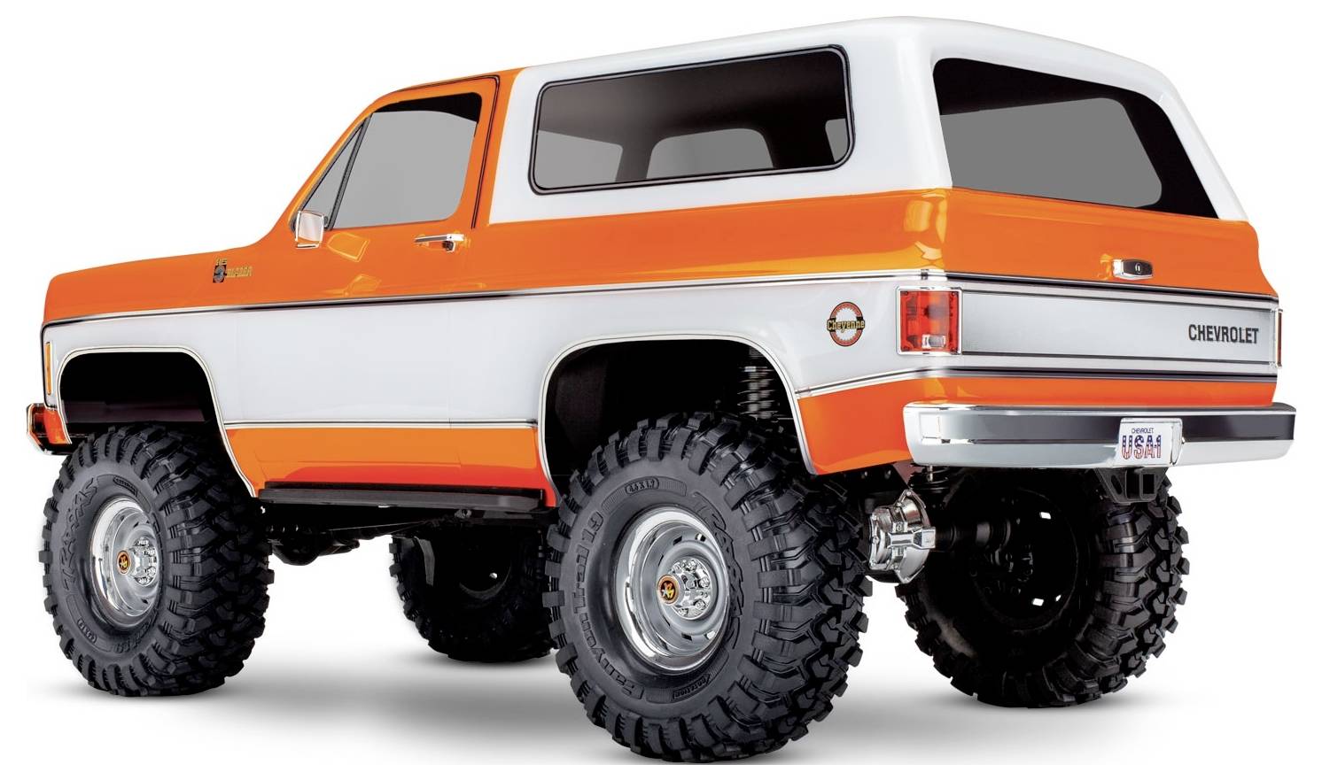 Un SUV d'epoca con una carrozzeria dipinta in arancione e bianco, sospensioni rialzate e pneumatici fuoristrada di grandi dimensioni, ripreso da un'angolazione posteriore laterale.