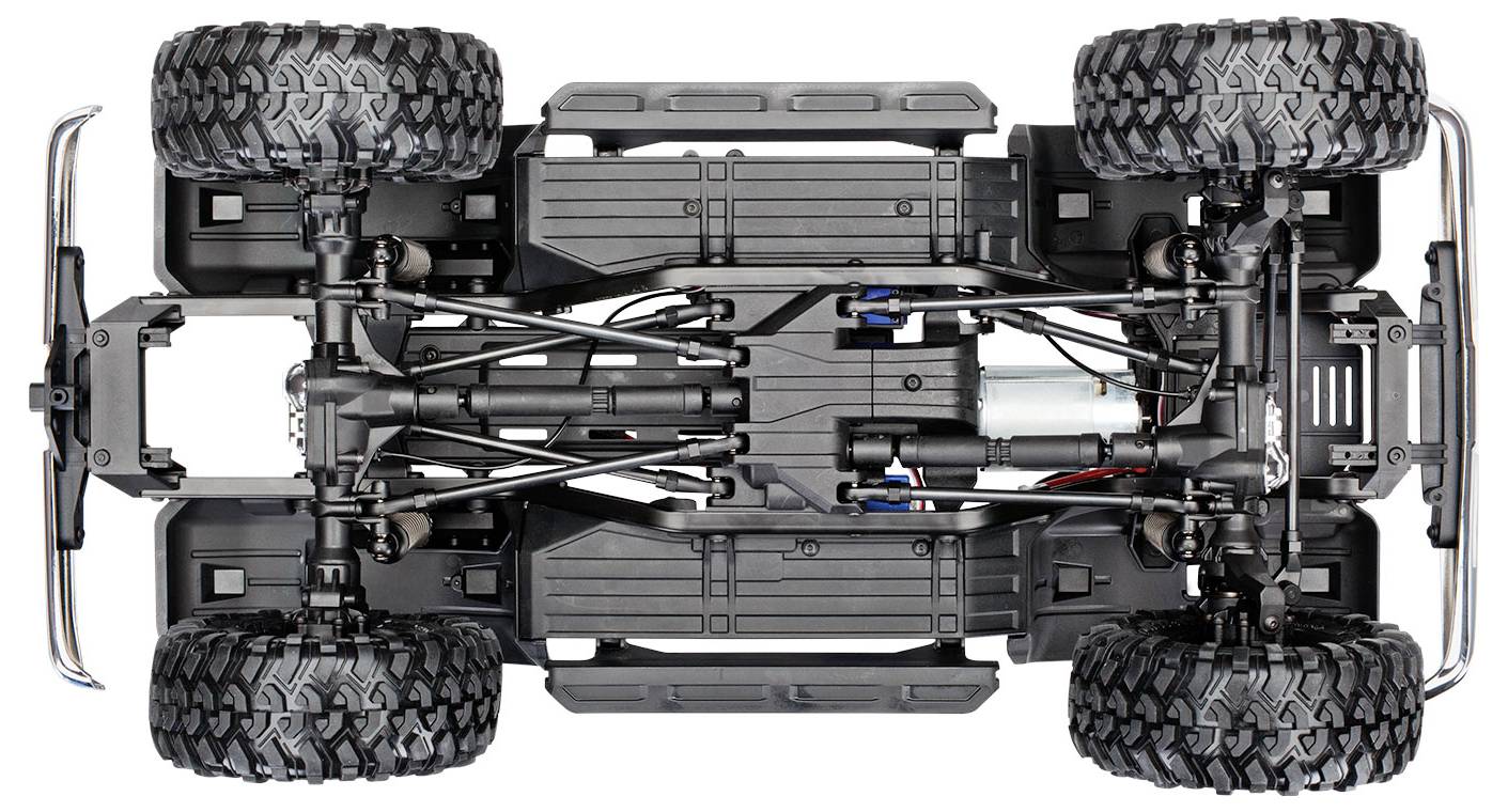 Vista dal basso del telaio di un'auto radiocomandata, che mostra dettagliatamente la sospensione, la trasmissione e pneumatici robusti e grandi.