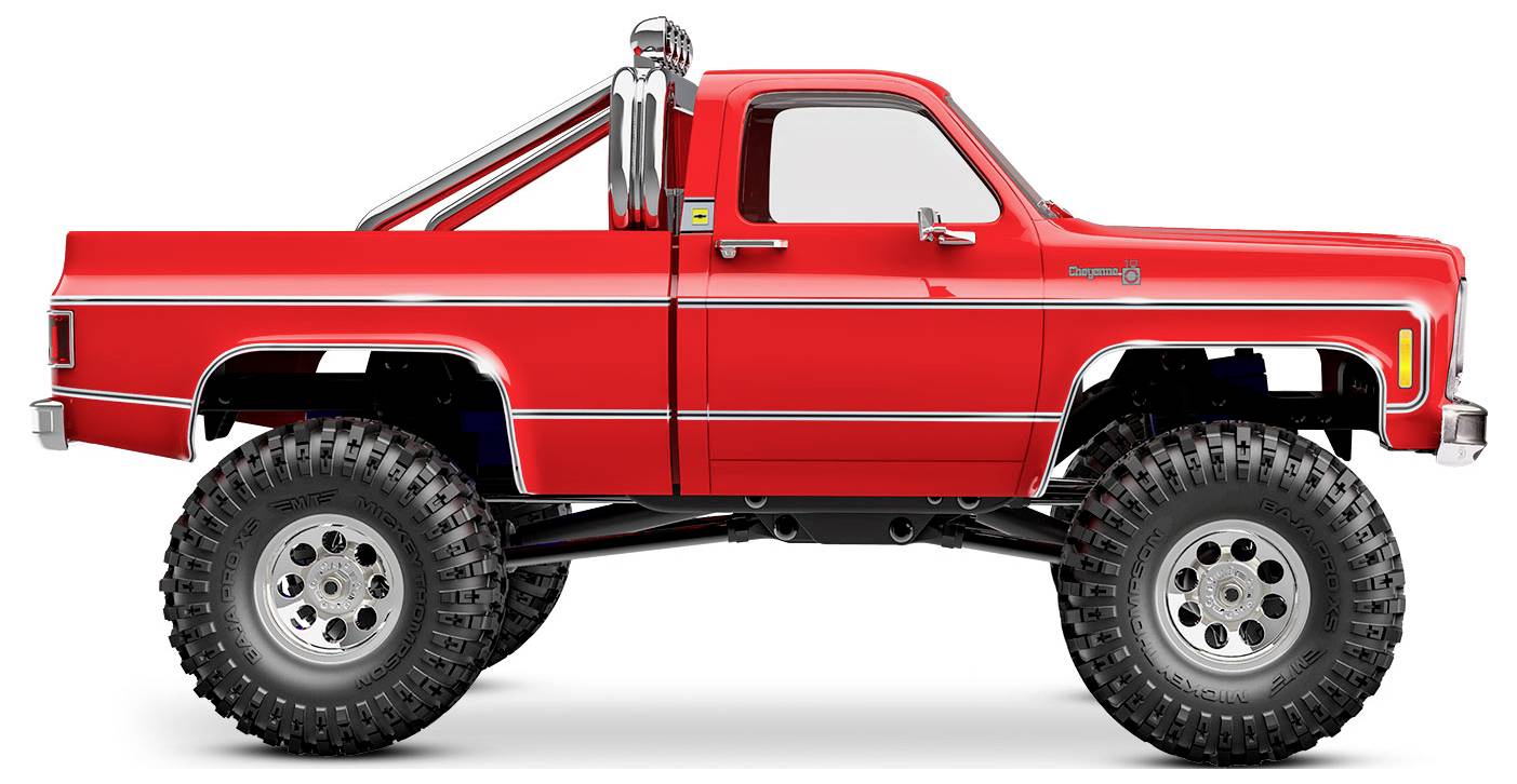 Un pick-up rosso brillante sollevato con pneumatici sovradimensionati e dettagli cromati sui lati e sui tubi di scarico.