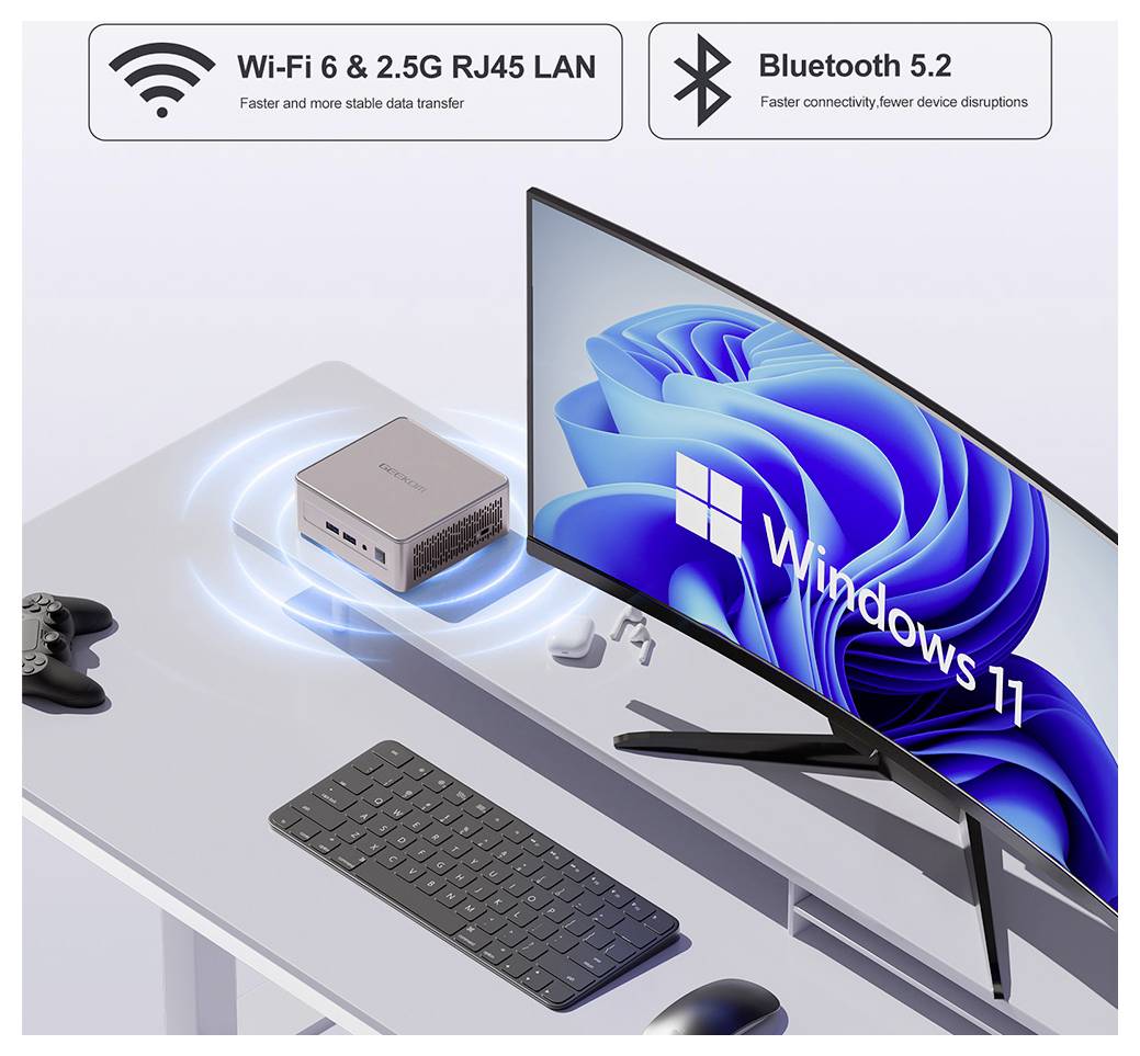 Una configurazione desktop con un monitor curvo che mostra 'Windows 11', un computer compatto accanto, una tastiera, un mouse e un controller per videogiochi.
