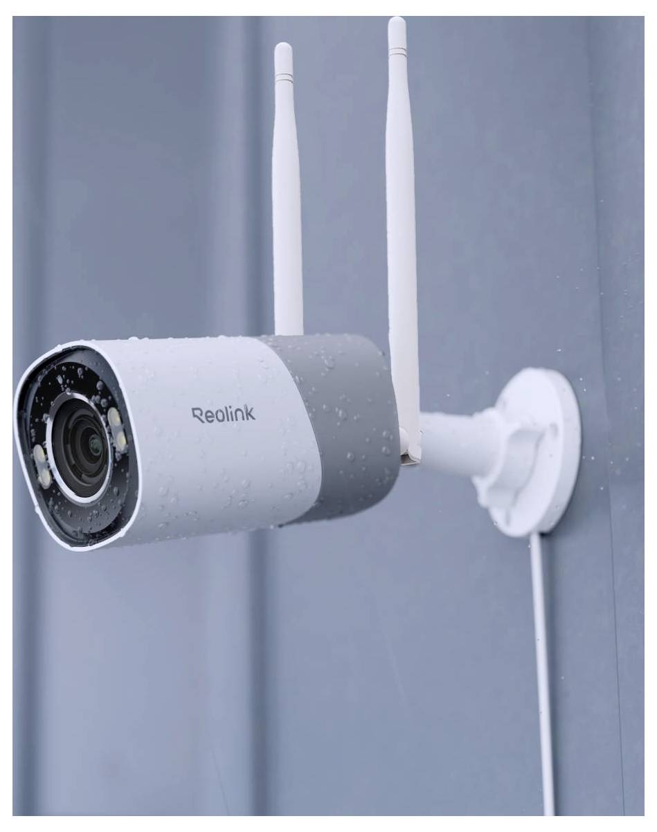 Una telecamera di sicurezza con antenna montata su un muro esterno, con gocce di pioggia sulla sua superficie, che indica l'utilizzo in condizioni meteorologiche piovose.