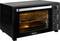 Forno elettrico da piano di lavoro nero con porta trasparente, due griglie in filo all'interno e manopole di controllo sul lato per regolare le impostazioni.