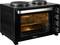 Un forno tostapane nero da bancone con due piastre riscaldanti in cima, porta in vetro leggermente socchiusa e manopole di controllo sul lato destro.