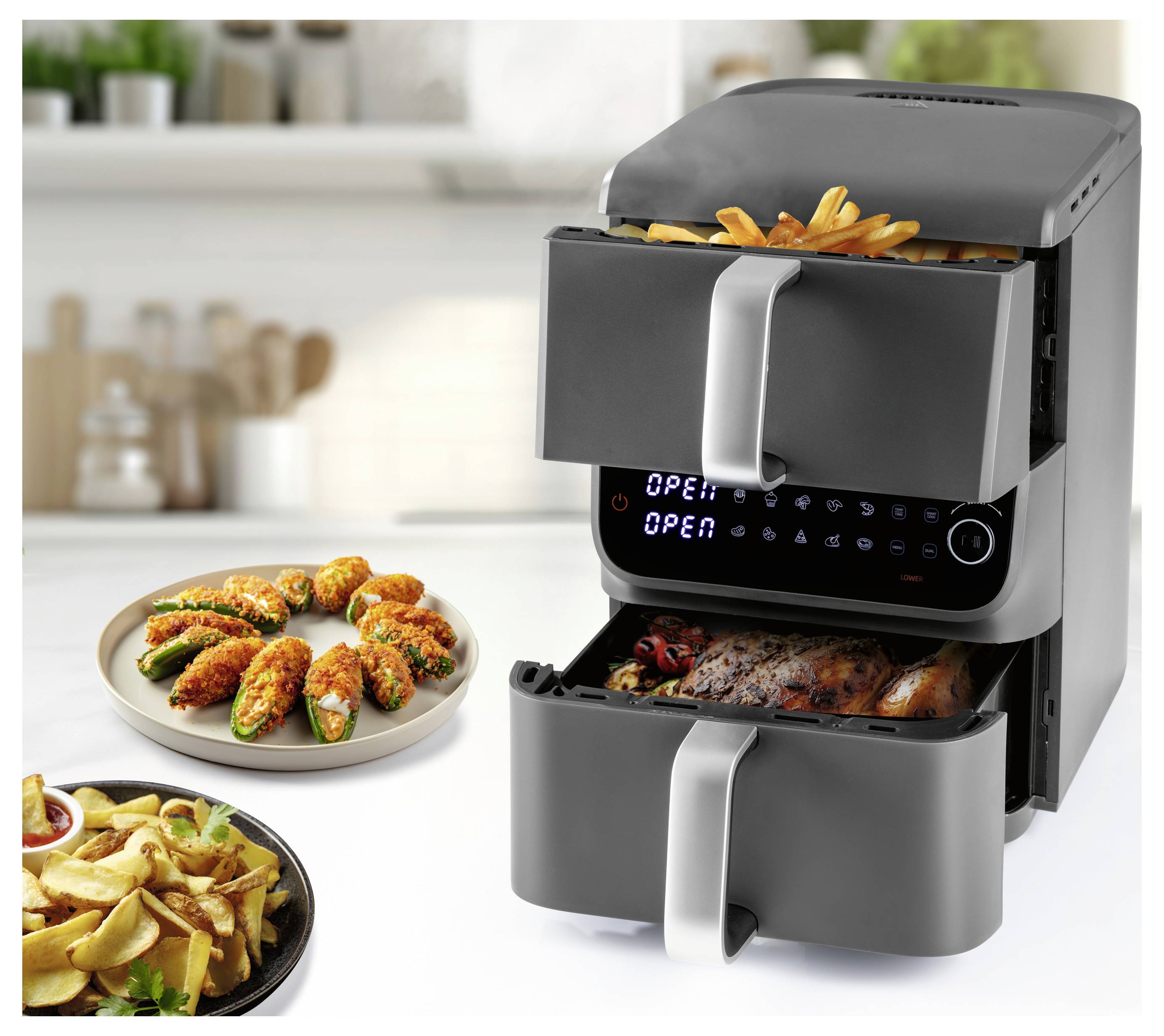 Un friggitrice ad aria a doppio cassetto con comandi digitali, che cuoce patatine fritte e pollo. Piatti con patatine fritte e jalapeños ripieni sono vicini in un ambiente di cucina.