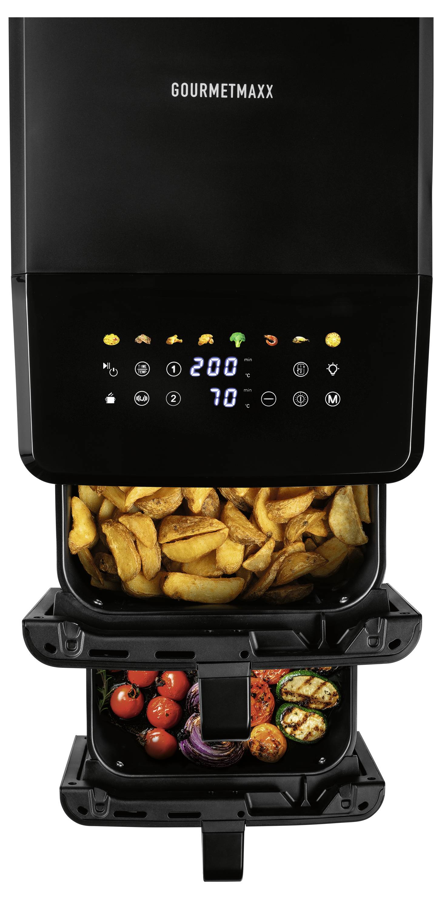 Una friggitrice ad aria nera a doppio comparto con comandi digitali nel comparto superiore, che sta cucinando patate a fette, pomodorini, verdure grigliate e cipolla.