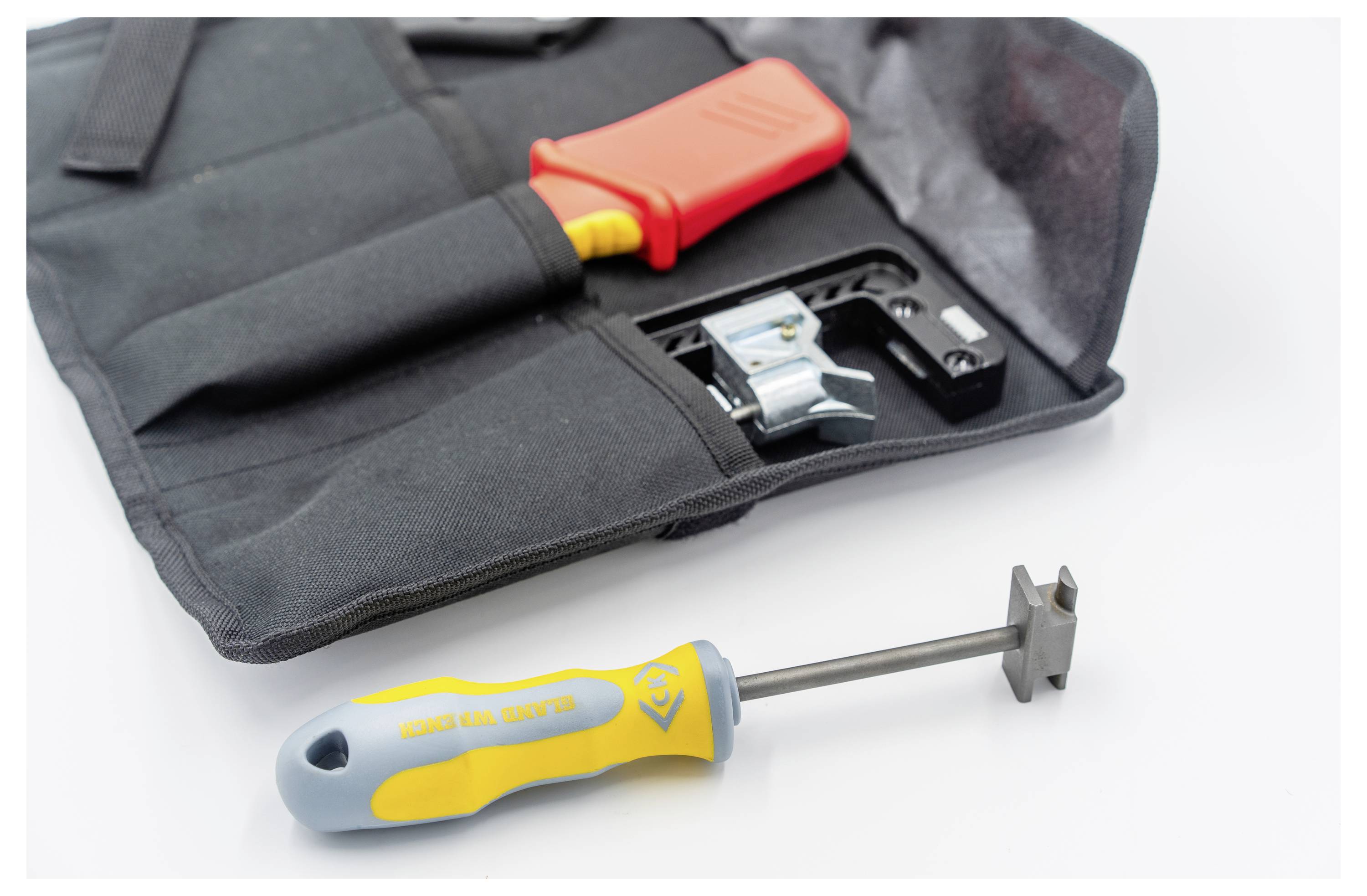 Un kit di strumenti con uno strumento di spellatura cavi rosso in una custodia nera e uno strumento con manico giallo e estremità metallica posizionato accanto ad esso.